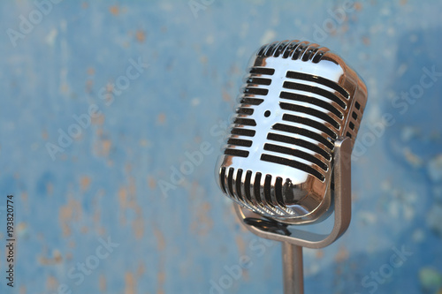 Vintage fashion metal microphone on blue wall background