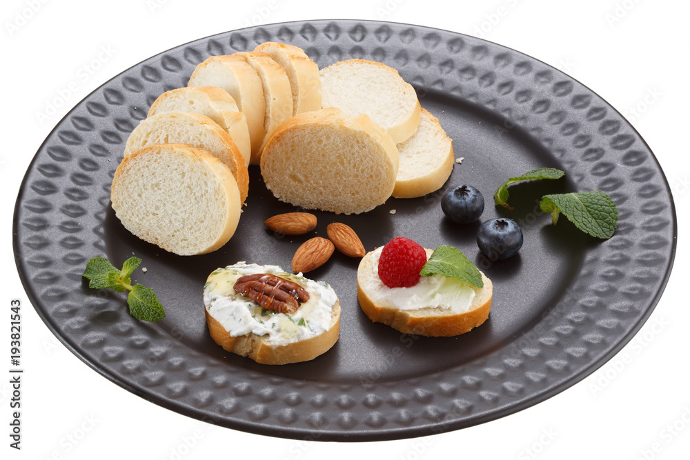 Sandwiches with mascarpone cream cheese, fresh berries and nuts on a black plate. Isolated on a white background. Sandwiches with mascarpone cream cheese, fresh berries and nuts on a black plate. Isolated on a white background.