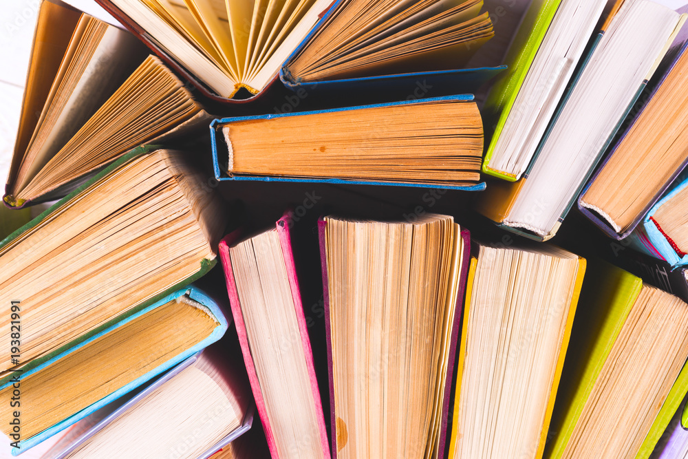 Fototapeta premium Open book, hardback books on bright colorful background.