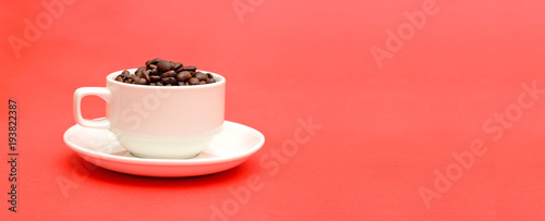 Cup full of roasted coffee beans on red banner template