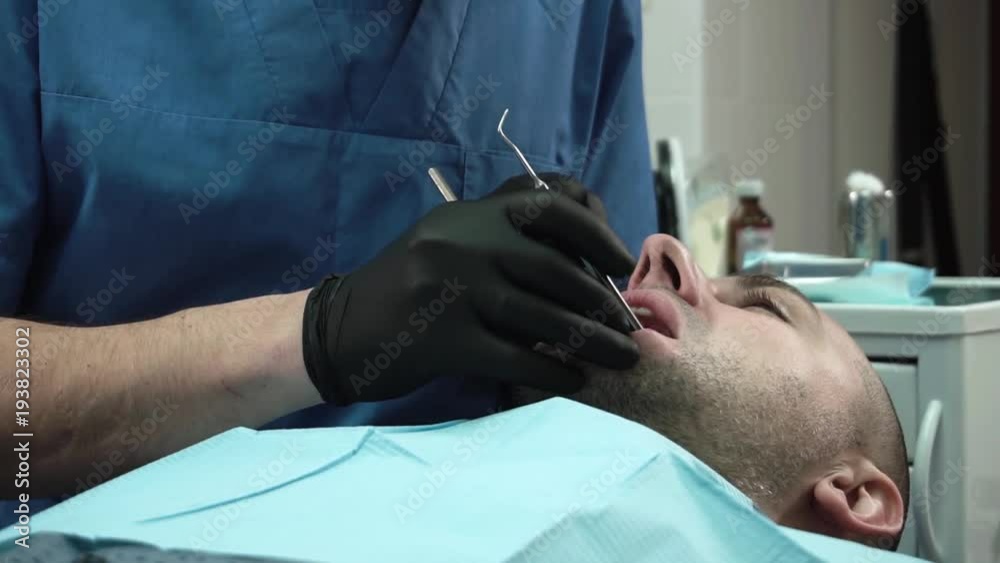 Dentist Doing Dental Treatment To Patient Dentist Doing Dental Treatment To Patient