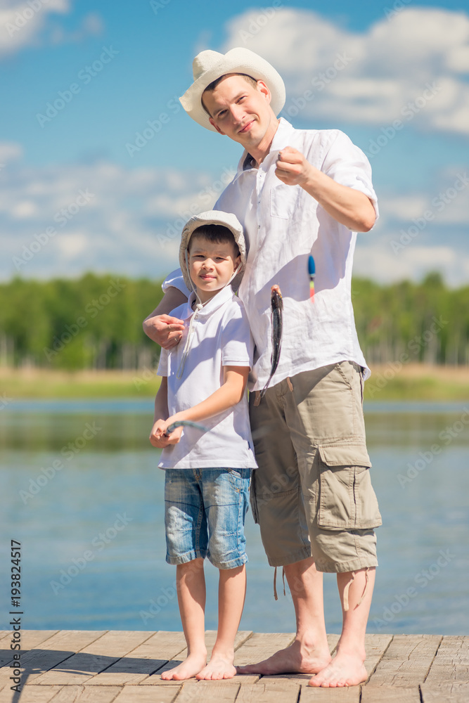 happy fishermen on the pier with a big fish on the hook, fishing on the lake happy fishermen on the pier with a big fish on the hook, fishing on the lake