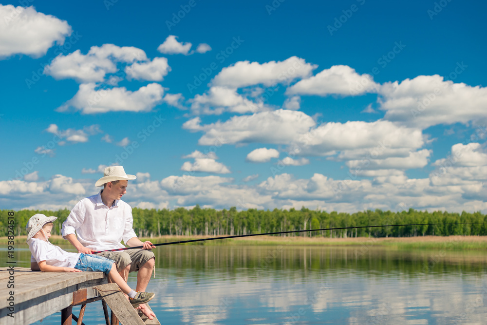 relaxed boy with his father on a fishing trip on a beautiful lake relaxed boy with his father on a fishing trip on a beautiful lake