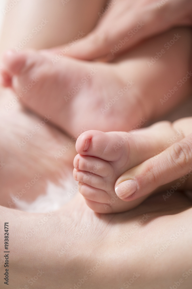Baby feet in mother hands. Close up of little baby feet in hands of mother.Selective focus Baby feet in mother hands. Close up of little baby feet in hands of mother.Selective focus