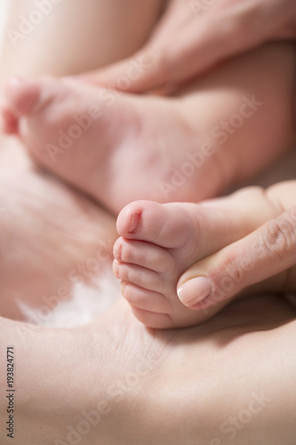 Baby feet in mother hands. Close up of little baby feet in hands of mother.Selective focus