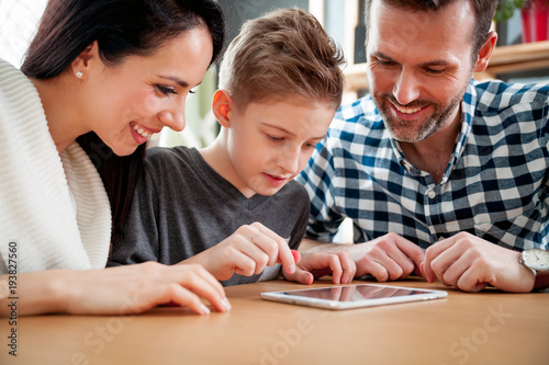 Happy family using tablet together at home