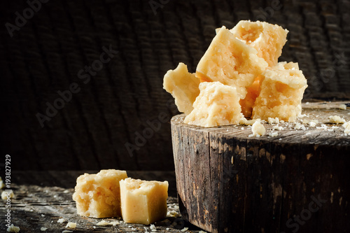 pieces of Parmesan cheese on a dark wooden background.