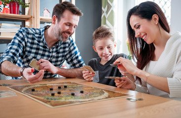 Happy family playing board game at home
