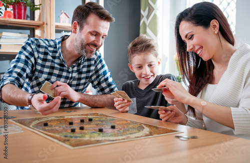 Happy family playing board game at home