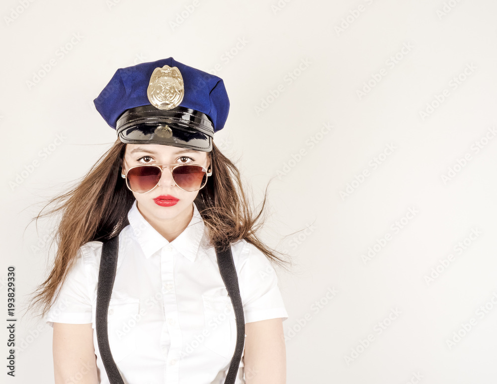 Fotografie Nice girl in a uniform of police officer on a white background