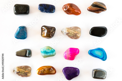 Collection of colorful polished semiprecious gemstones on white background