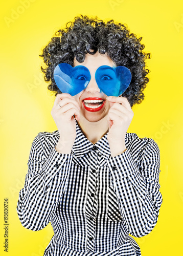 Funny girl with hearts in front of her eyes. A sign of love. Indoor, studio shot, isolated on light background