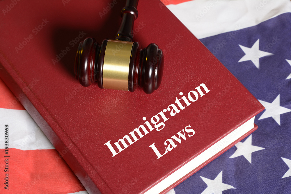 Immigration Laws book with Gavel on USA flag Immigration Laws book with Gavel on USA flag
