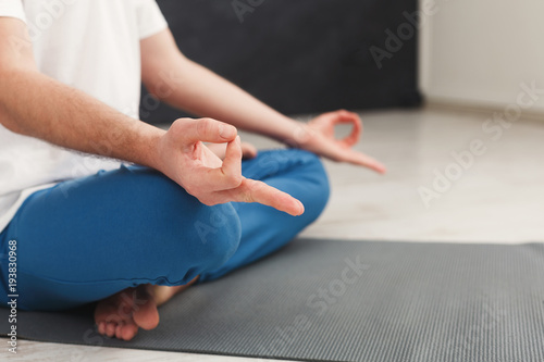 Young man meditating in gym