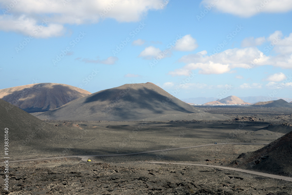Little yellow car drives up the volcano