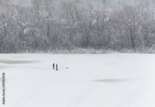 Winter fishing on the ice of a frozen river is a popular winter hobby in russia