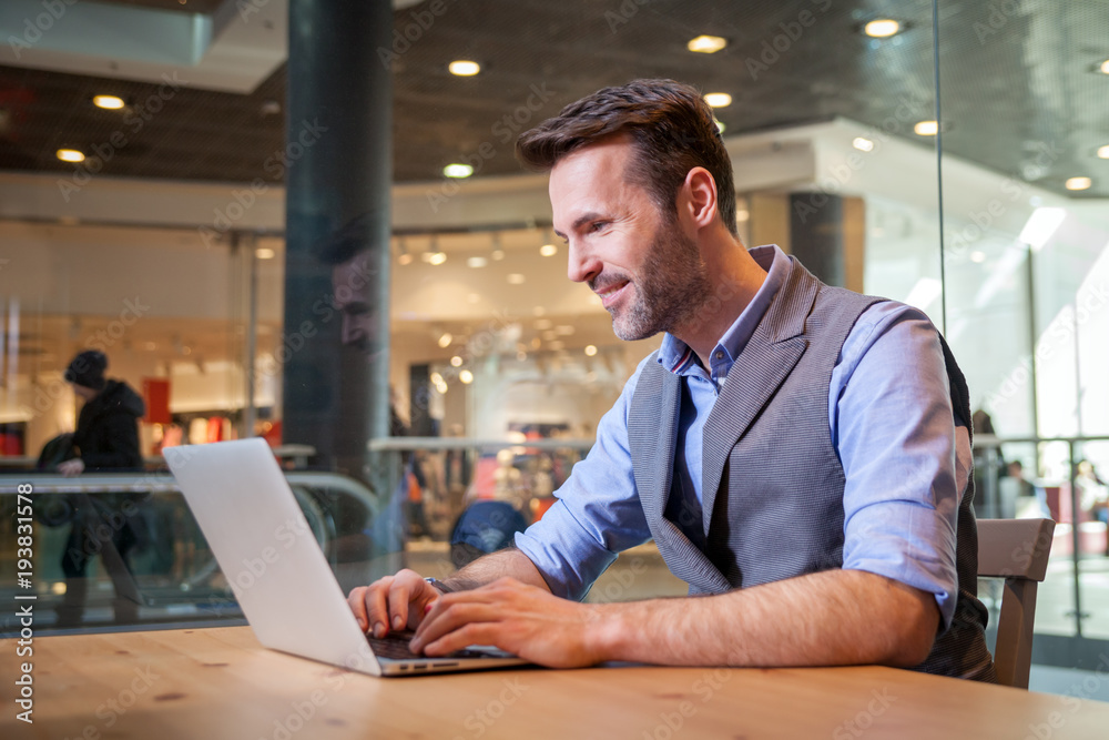 Confident businessman using laptop in modern interior Confident businessman using laptop in modern interior