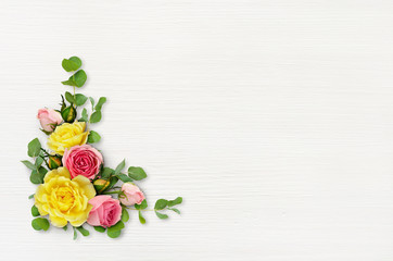 White wooden background with rose flowers and eucalyptus leaves