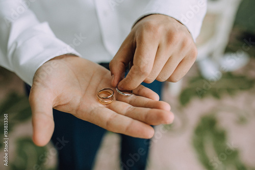 A man holds in his hands on the palms of the wedding gold rings. Close-up