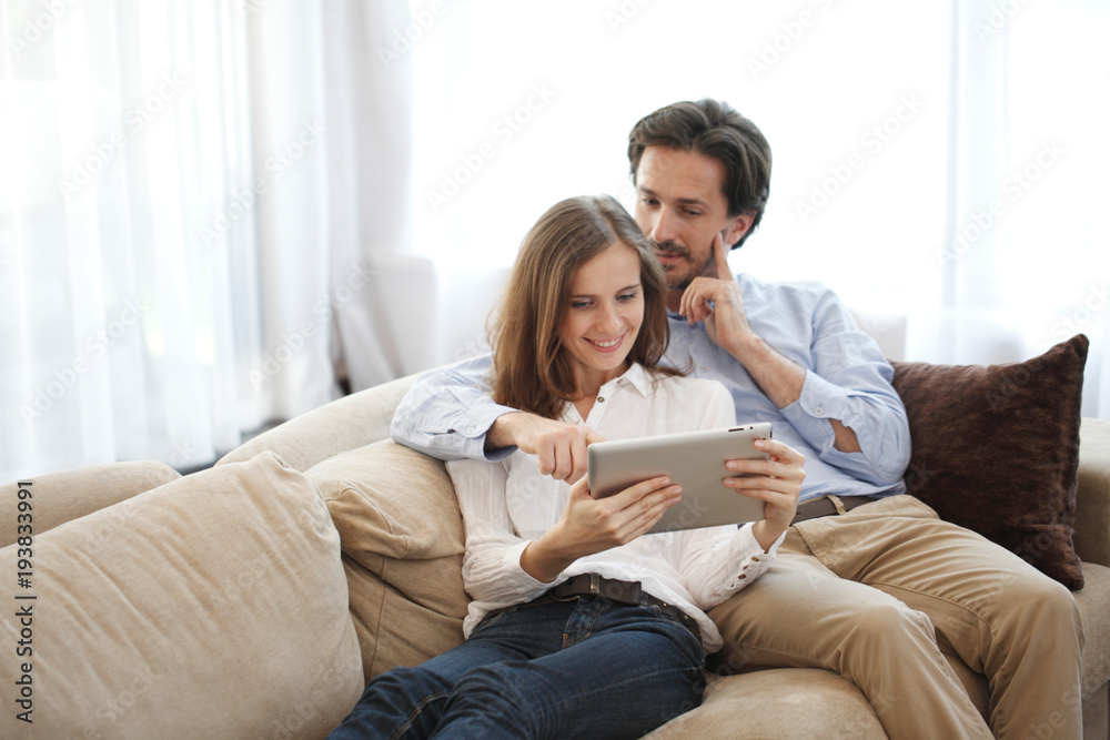 Cheerful couple using tablet