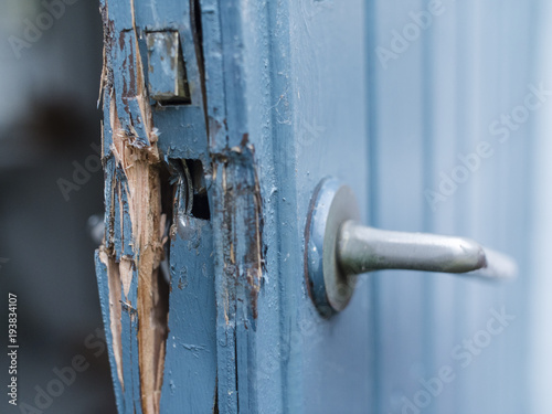 Broken door in blue and white colors after a burglery photo