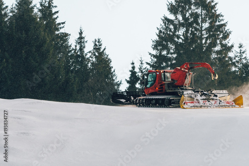 Red snowcat on snow in the winter in mountains