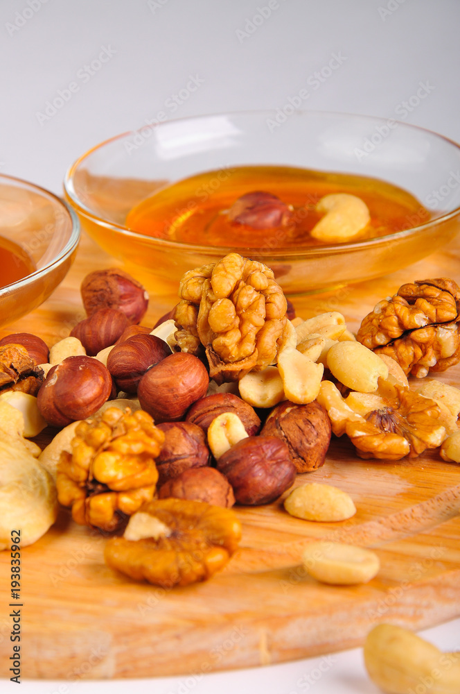 honey with a mix of nuts on a wooden Board honey with a mix of nuts on a wooden Board