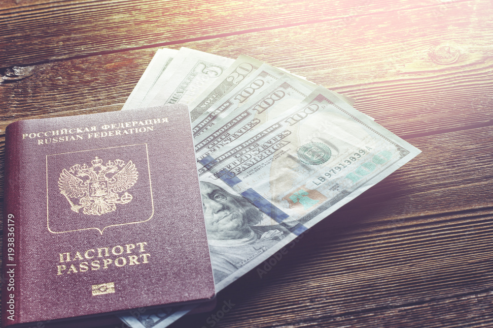 Passport and dollars on a wooden table Passport and dollars on a wooden table