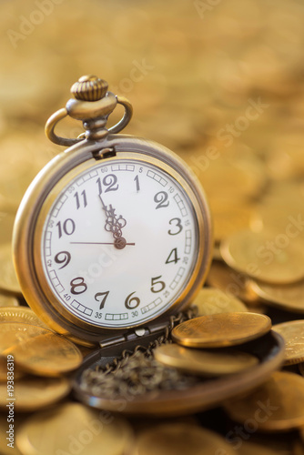 vintage pocket watch on the gold coins background