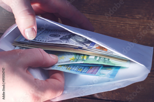 Hands pulling money from the envelope