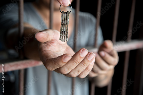 Fototapeta giving a key to released prisoner with begging hand in jail