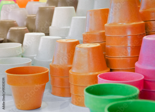 Selective focus/ Colorful of plastic pots for sale. orange, pink and white pots.