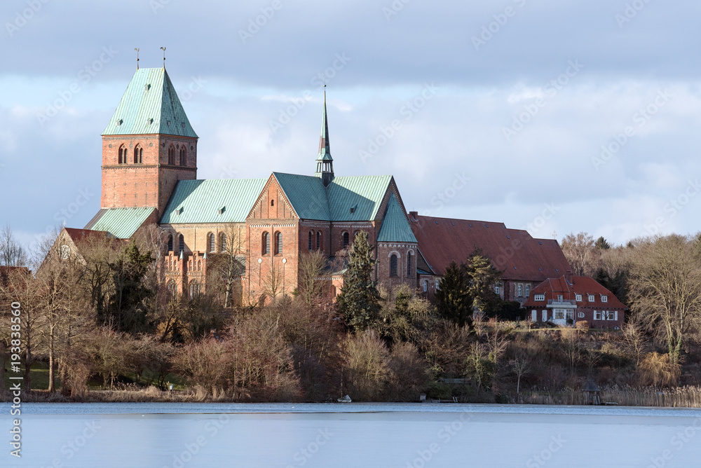 Cathedral or Dom of Ratzeburg seen from the Domsee lake in winter, an historic brick romanesque building in northern Germany, copy space