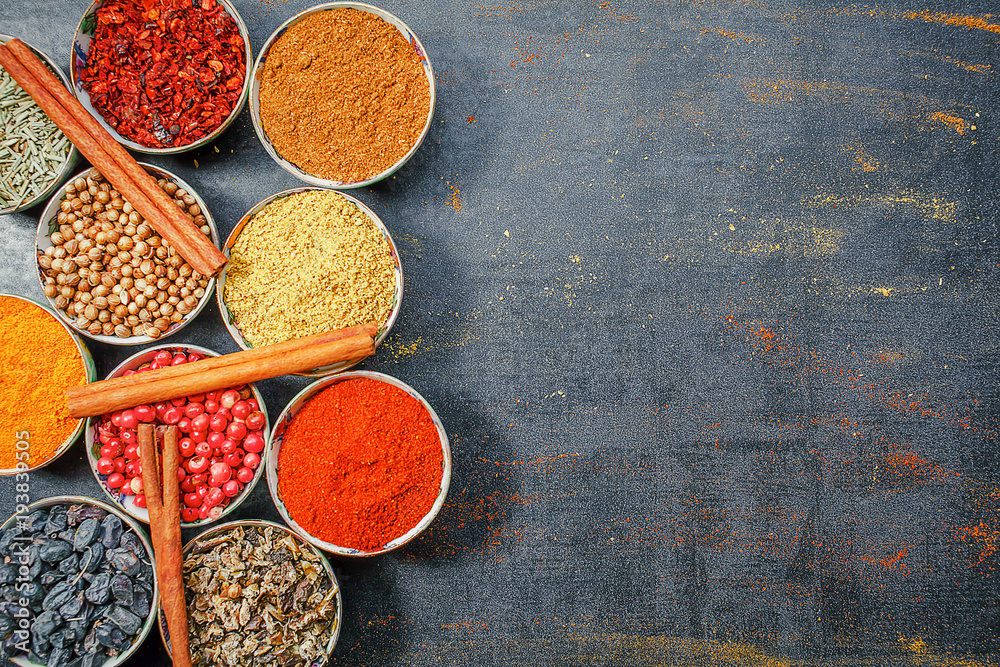 Fototapeta premium Spices and herbs. Variety of spices and mediterranean herbs on black stone