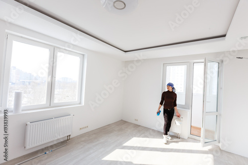 Smiling woman cleaning the panes of her living room