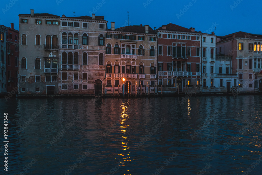 Typical Venetian canal with red houses at evening, Venice, Italy