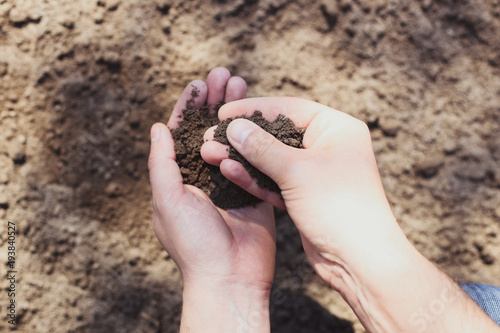 Agrarian with soil in his hands, quality control concept photo