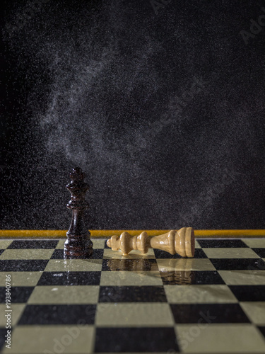 Chess figures on a dark background in the rain. Lose and win Concept. Selective focus
