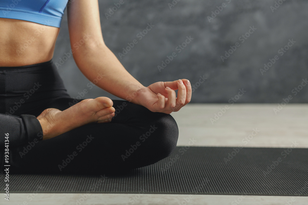 Unrecognizable woman training yoga in lotus pose