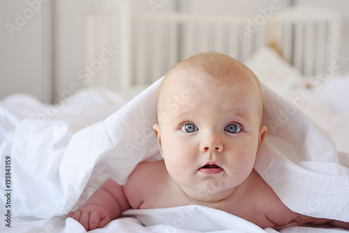 Cute baby lies in a bed