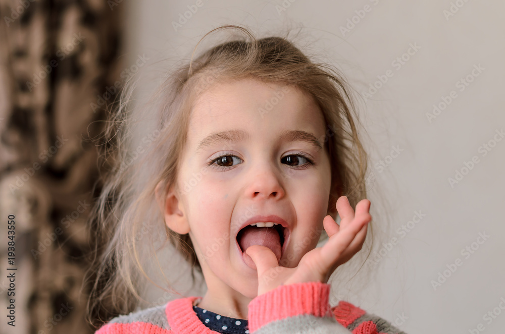 a little girl with puffy cheeks, dark shining eyes with long eyelashes with appetite licks the thumb of her left hand a little girl with puffy cheeks, dark shining eyes with long eyelashes with appetite licks the thumb of her left hand