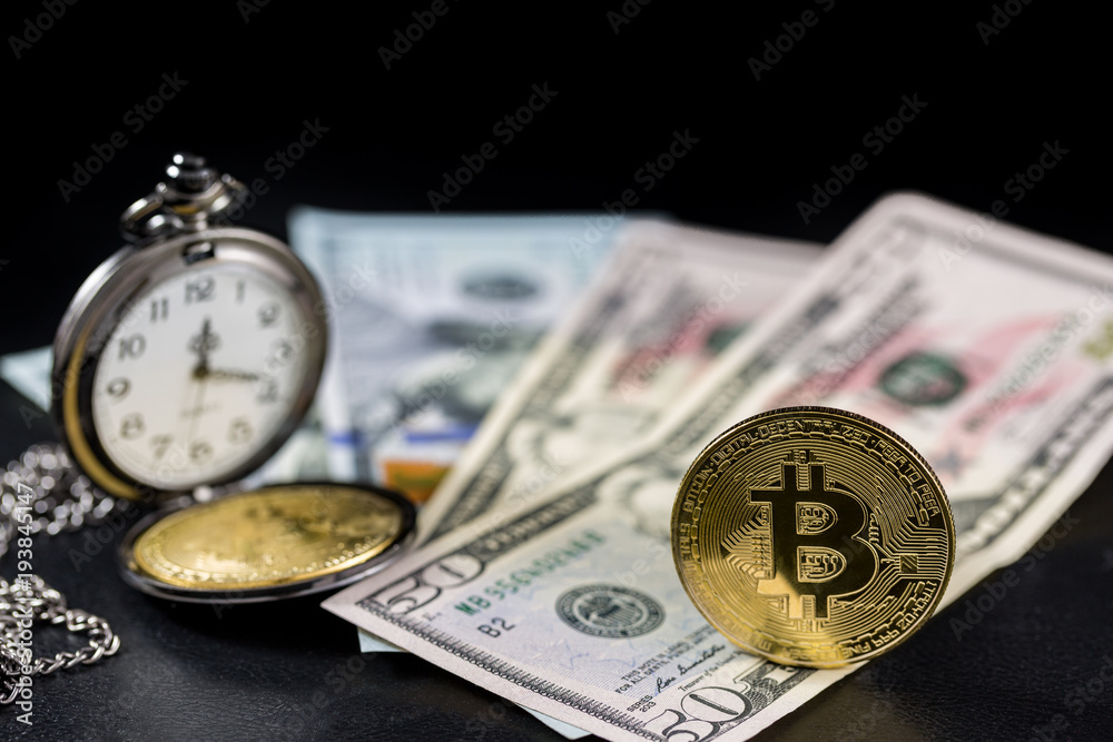Golden bitcoin standing and retro pocket watch on us dollars with black background Golden bitcoin standing and retro pocket watch on us dollars with black background