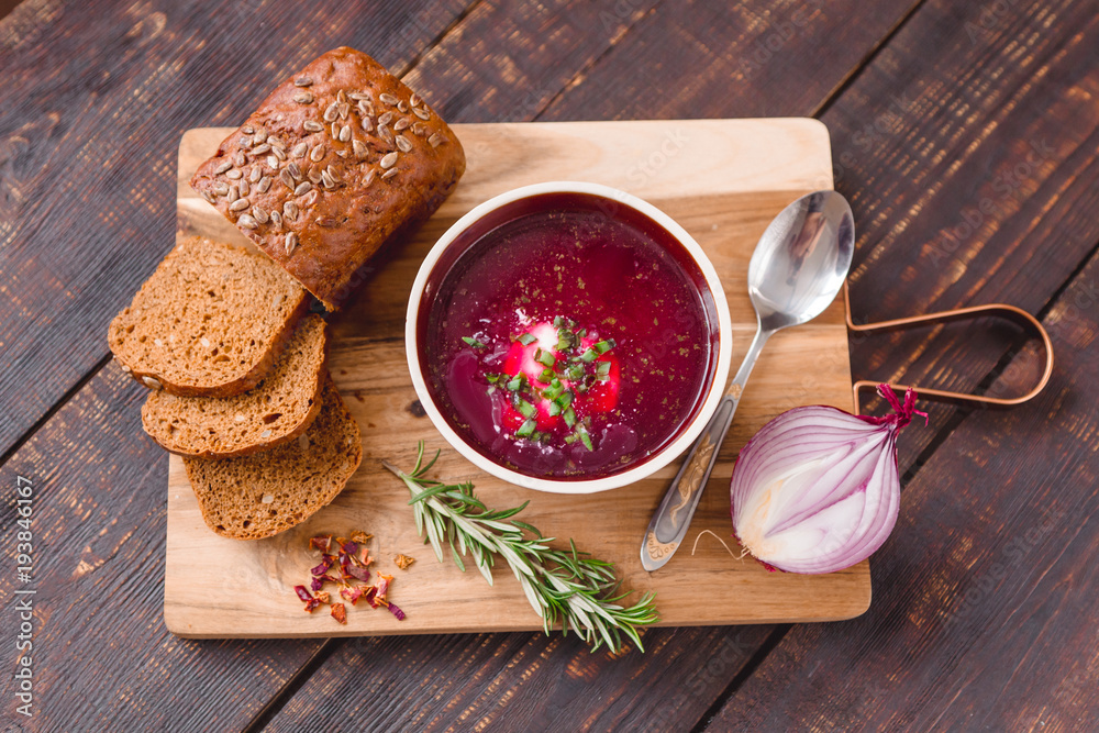 bowl of borscht with pieces of bread and onions on a wooden table bowl of borscht with pieces of bread and onions on a wooden table
