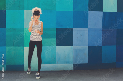 African-american woman posing at bright wall photo