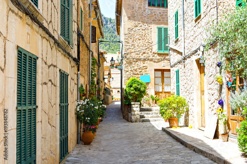 Fototapeta Naklejka Na Ścianę i Meble -  Beautiful street in Valldemossa with traditional flower decoration, famous old mediterranean village of Majorca. Balearic island Mallorca, Spain