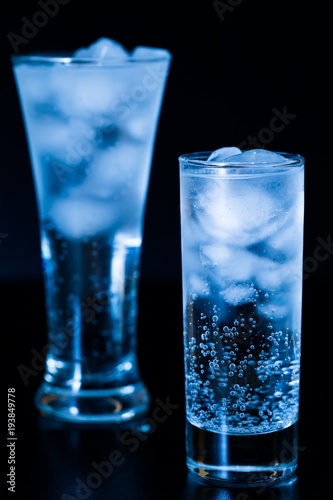 Drink. Water glass and ice, dark background