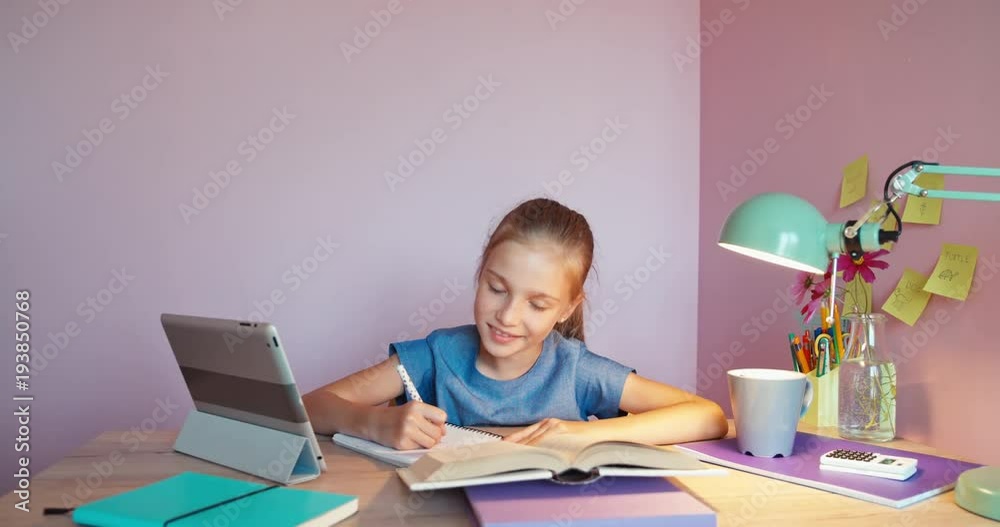 Student girl writing in the notebook and smiling at camera. Dolly shot zoom Student girl writing in the notebook and smiling at camera. Dolly shot zoom