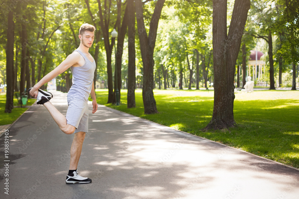 Fitness man stretching legs outdoors Fitness man stretching legs outdoors