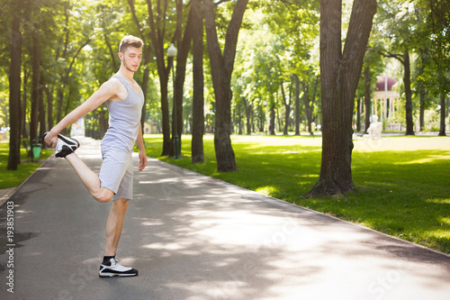 Fitness man stretching legs outdoors