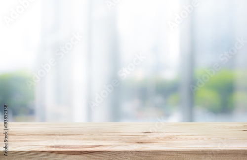 Wood table top on white abstract background form office building.